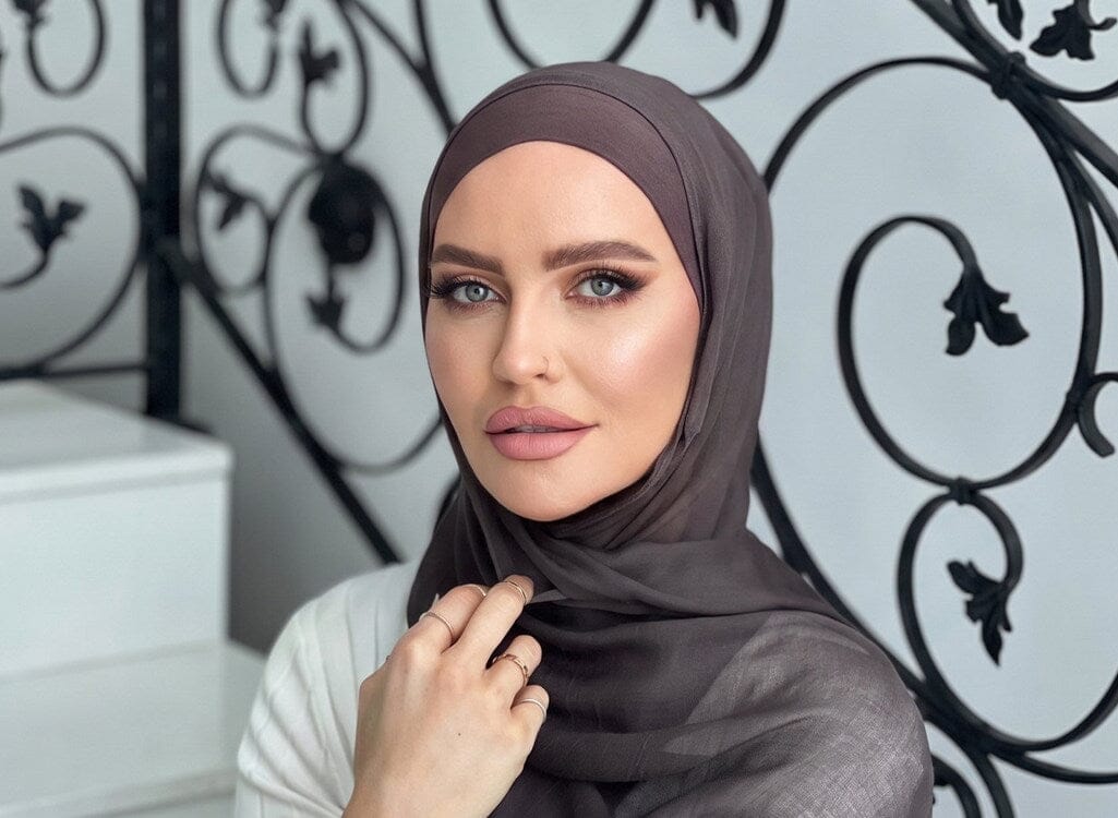 Woman wearing a draped grey-mauve chiffon hijab with soft crown styling